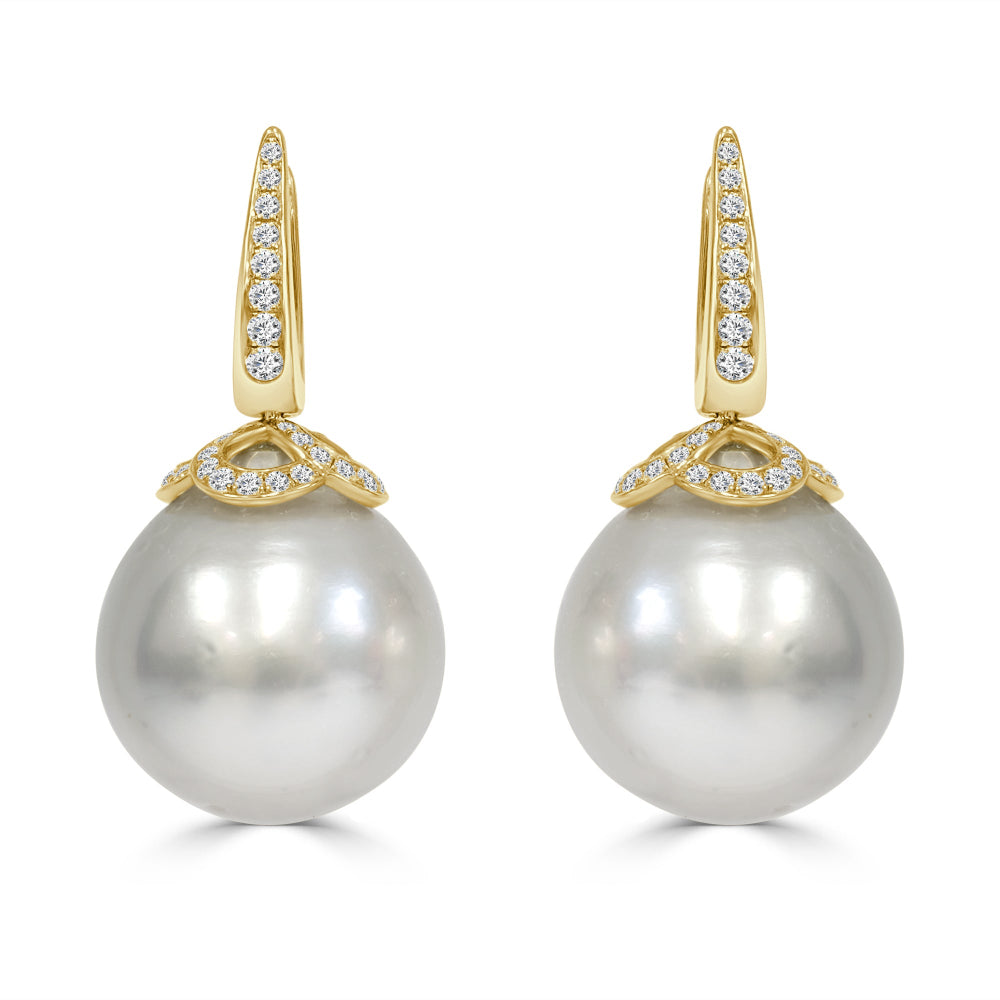 Pearl earrings with gold and diamond accents on a white background