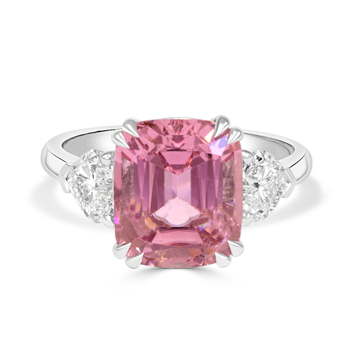 Ring with a pink tourmailine and heart shape diamond trilogy band on a white background