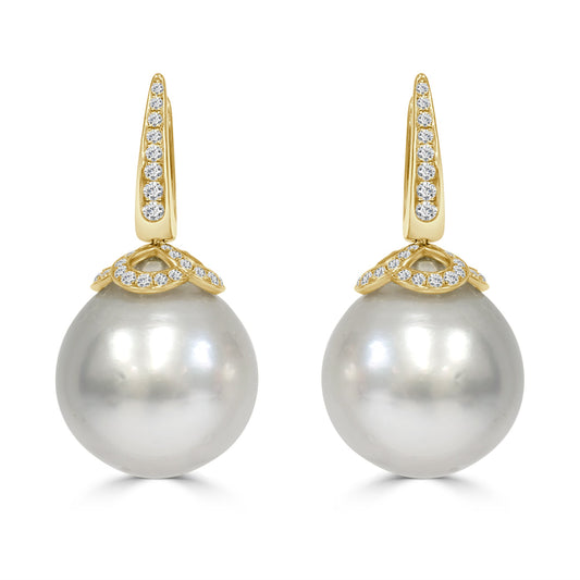 Pearl earrings with gold and diamond accents on a white background